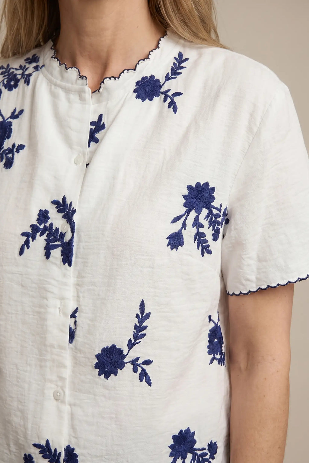 Camisa blanca con bordado floral azul – Frescura y estilo