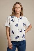 Camisa blanca con bordado floral azul – Frescura y estilo