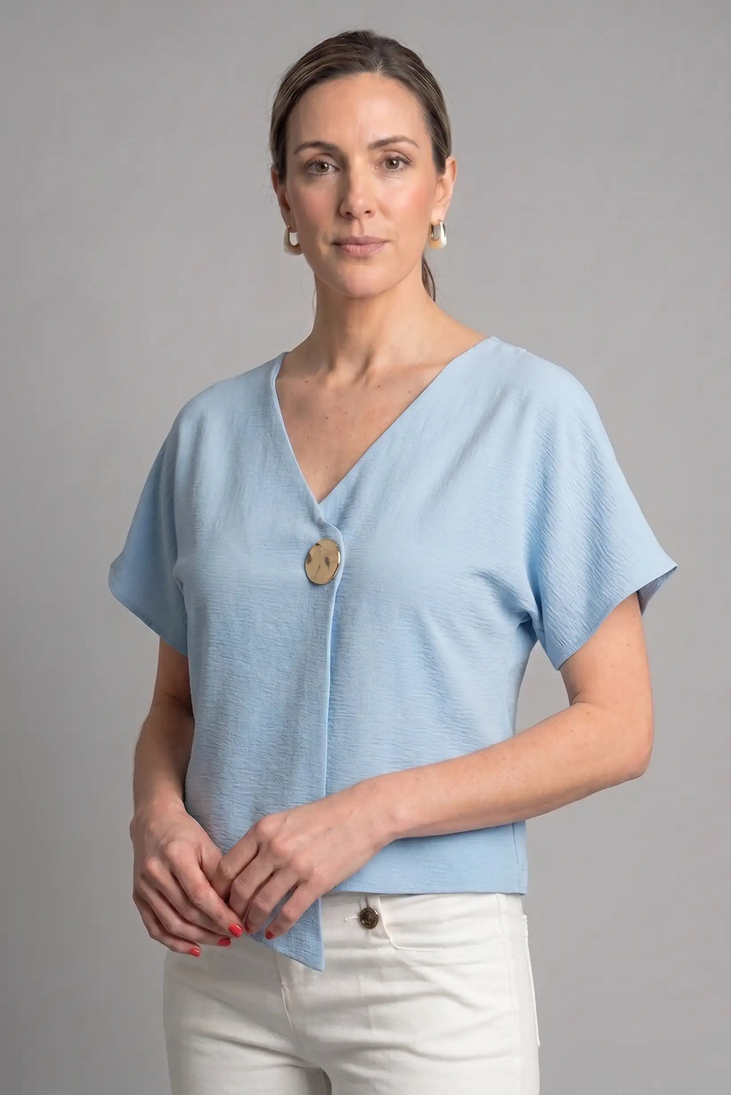 Top azul cielo cruzado de punto con botón dorado – Elegancia primavera/verano