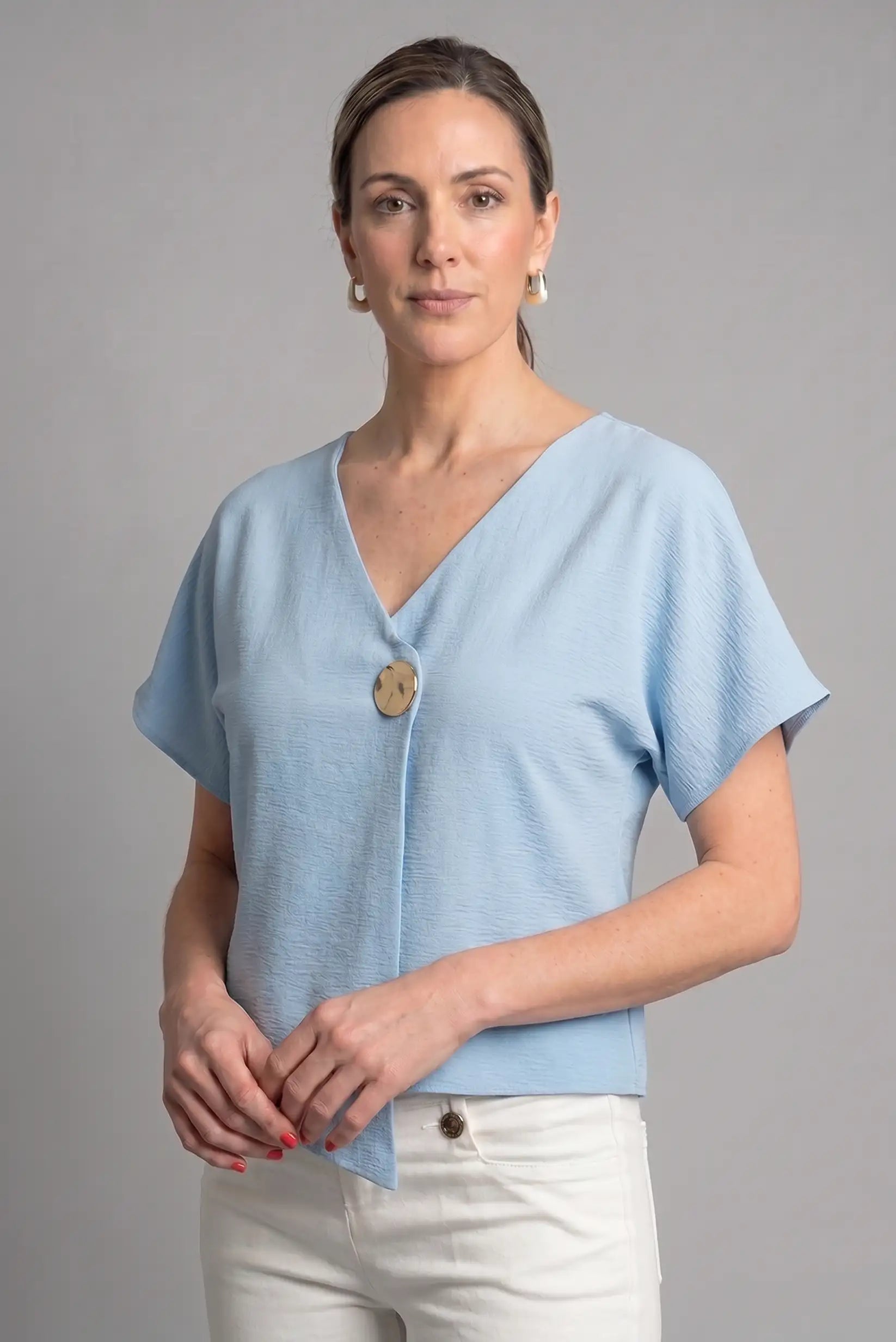 Top azul cielo cruzado de punto con botón dorado – Elegancia primavera/verano